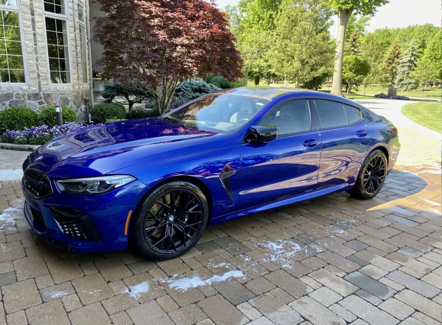 Blue BMW M8 Competition in the driveway after a wash